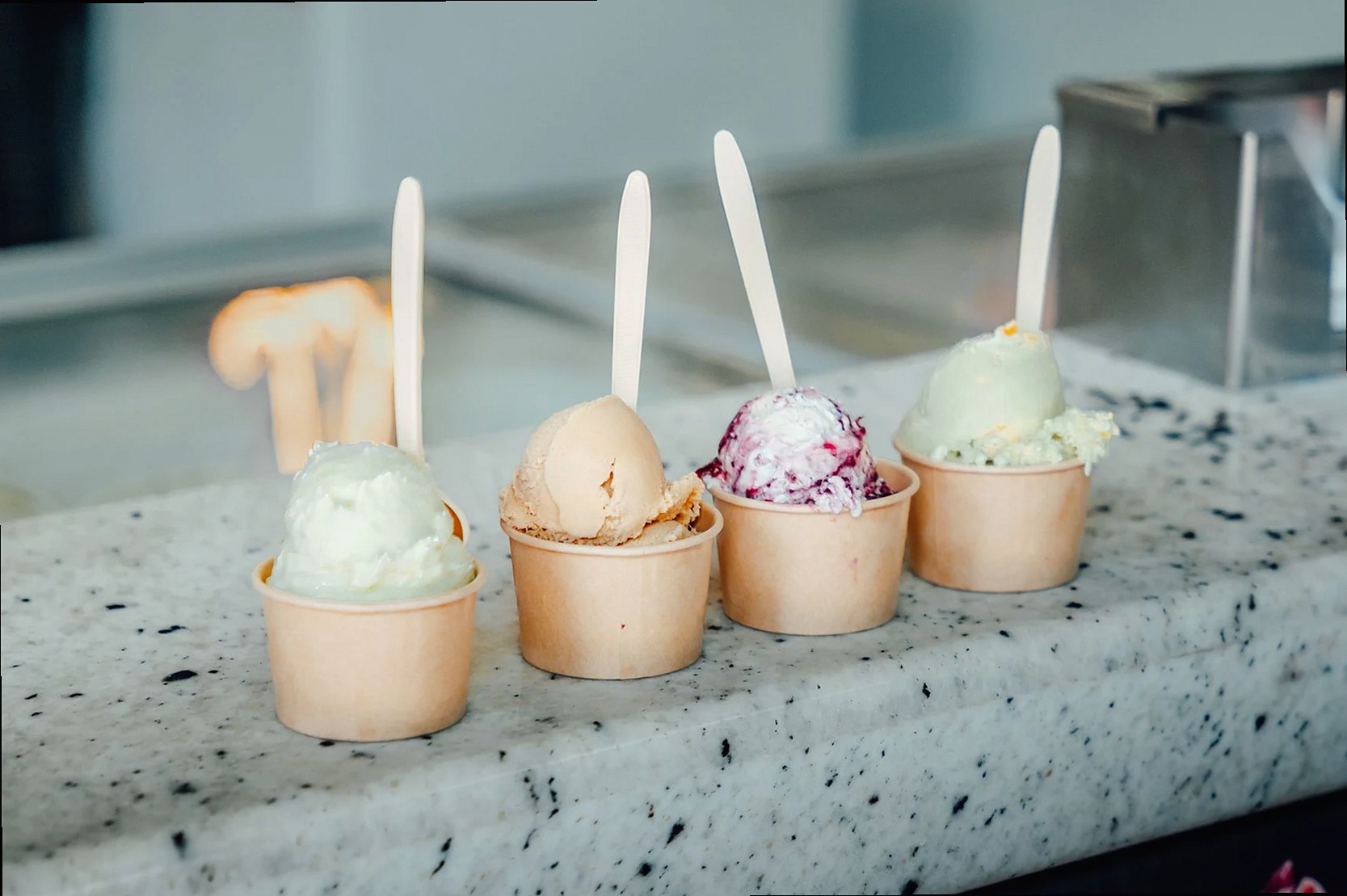 Coloridas bolas de helado en vasos con cucharas, perfectas para los amantes del postre en una heladería mexicana.